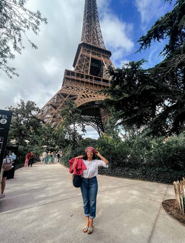 Girl standing next to the Eiffel Tower